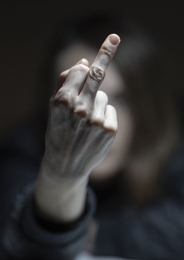 image : une femme tend un doigt d'honneur